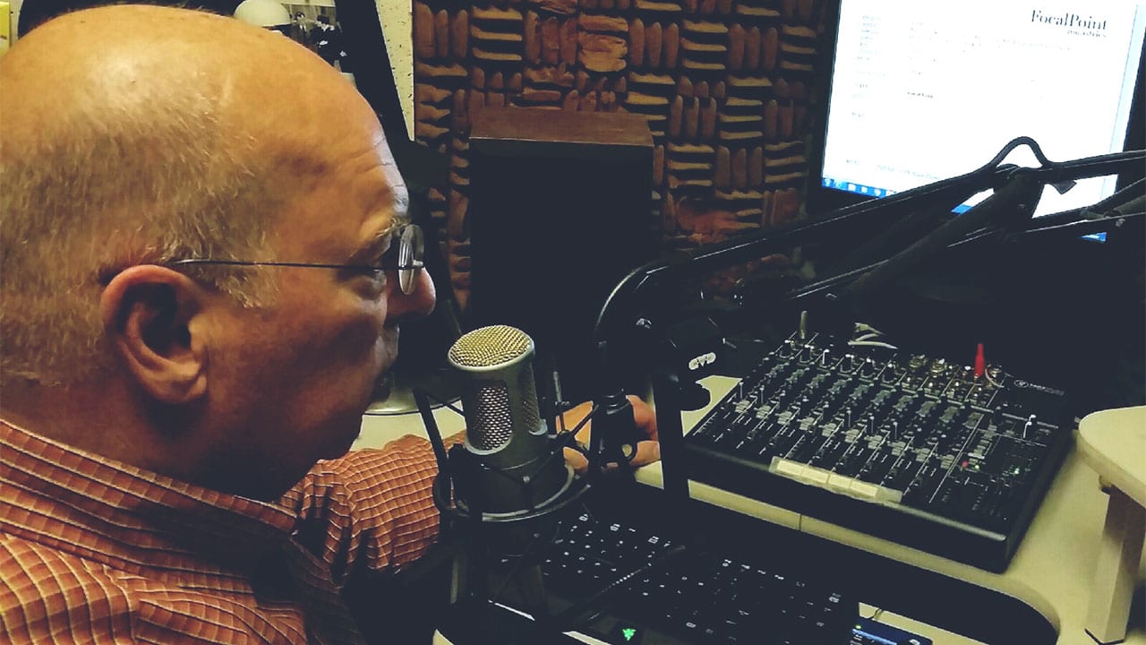 man at a sound board working on Pastor Mike's sermon recordings